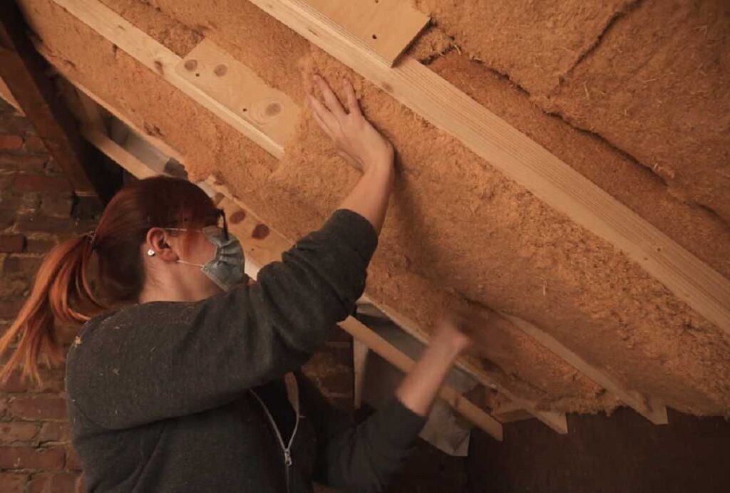 Woman installing roof insulation