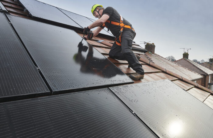 A work person installing solar panels.