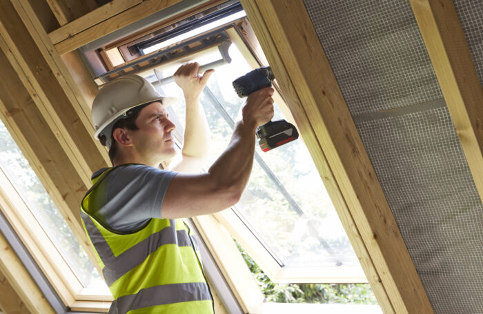 A builder fitting a window