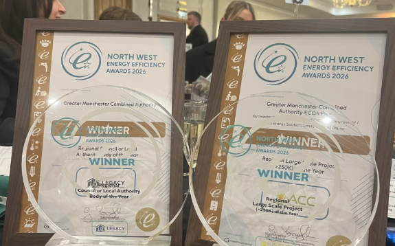 Awards on a table with certificates behind